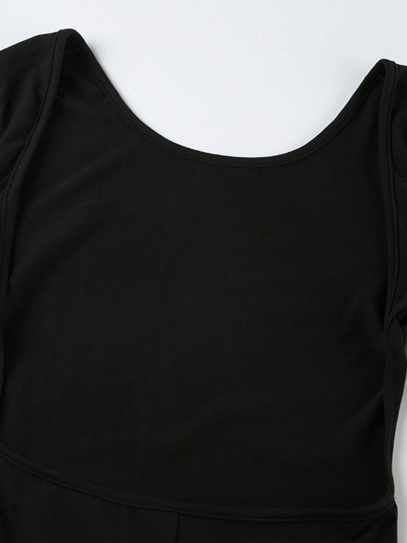 Black long-sleeve active romper with boat neck and body contouring fit