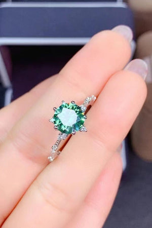 Emerald cut moissanite platinum ring with celestial halo detail and small accent stones.