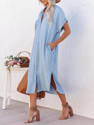 Light blue denim midi shirt dress with short sleeves, button front, pockets, and side slits.