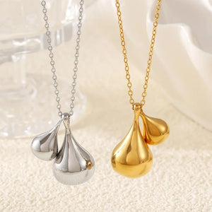 Polished gold and silver necklaces with sculptural teardrop pendants.