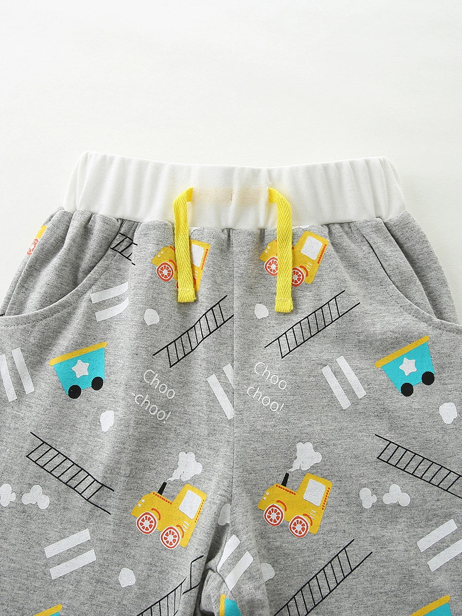 Toddler grey cotton shorts with yellow train print, white waistband, and yellow drawstring.