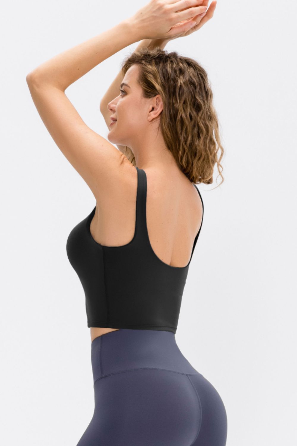Black performance scoop crop top with wide straps and a cropped fit.