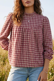 Burgundy plaid long sleeve blouse with button keyhole detail and gathered neckline.