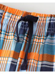 Toddler plaid shorts with elastic waist and drawstring in blue, orange, and white cotton.