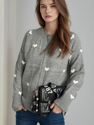 Gray zip-through knit sweater with white heart appliqué, crew neck, and long sleeves.