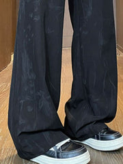 Black wide-leg trousers with subtle floral pattern and drawstring detail.