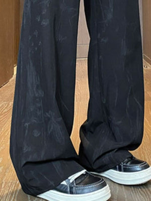 Black wide-leg trousers with subtle floral pattern and drawstring detail.