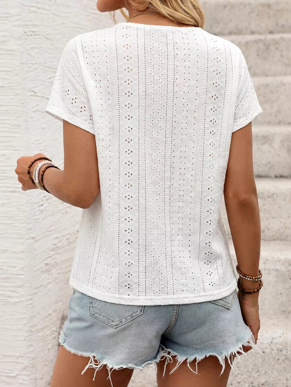 White embroidered eyelet V-neck t-shirt with short sleeves.