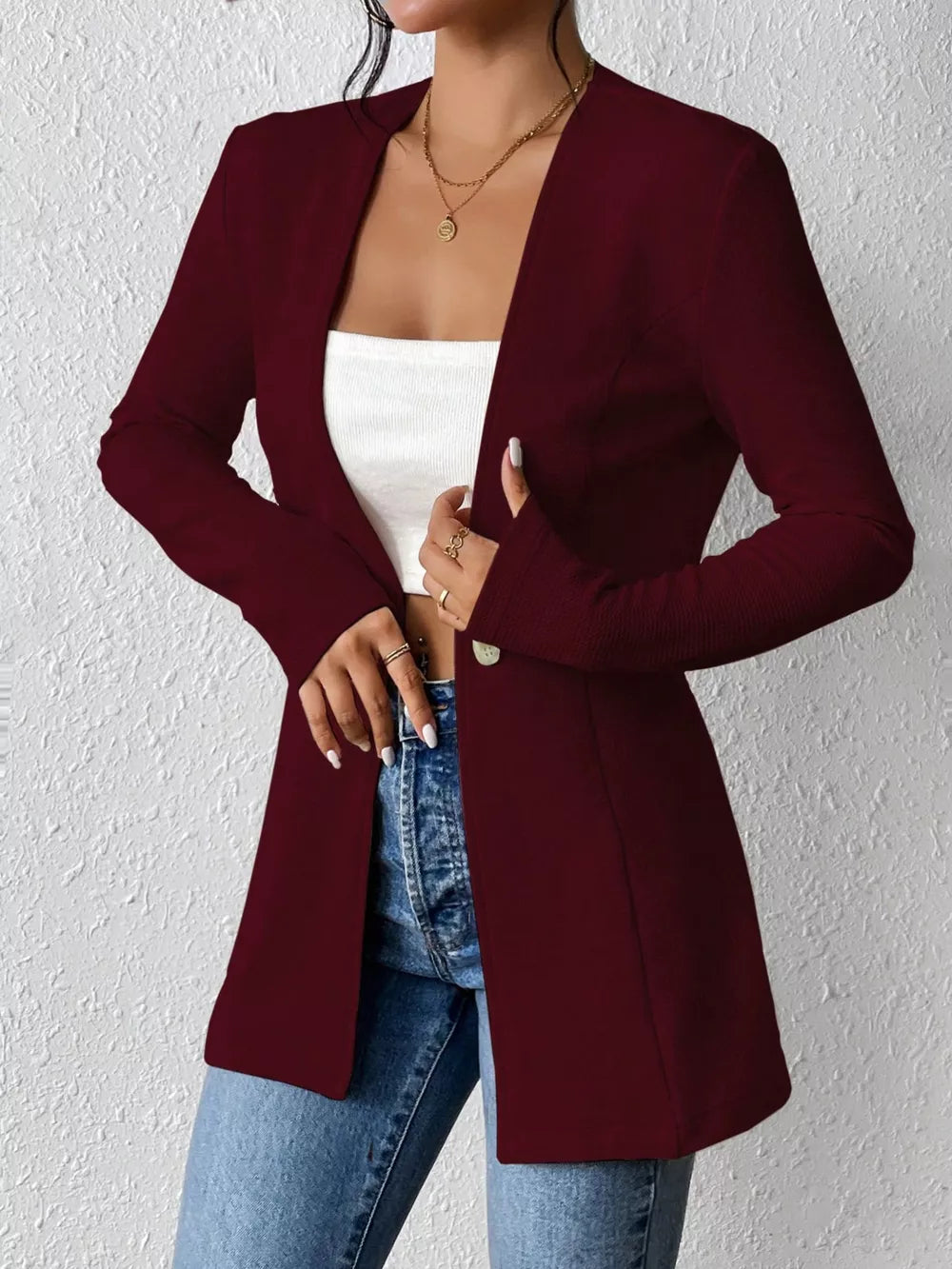 Wine red single-button blazer with tailored fit and open front, styled with jeans.