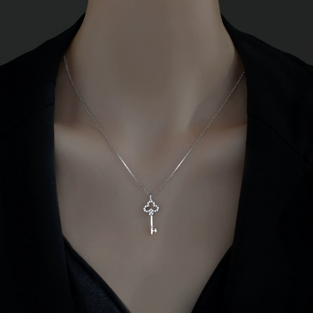 Delicate silver key pendant necklace with cubic zirconia accents.