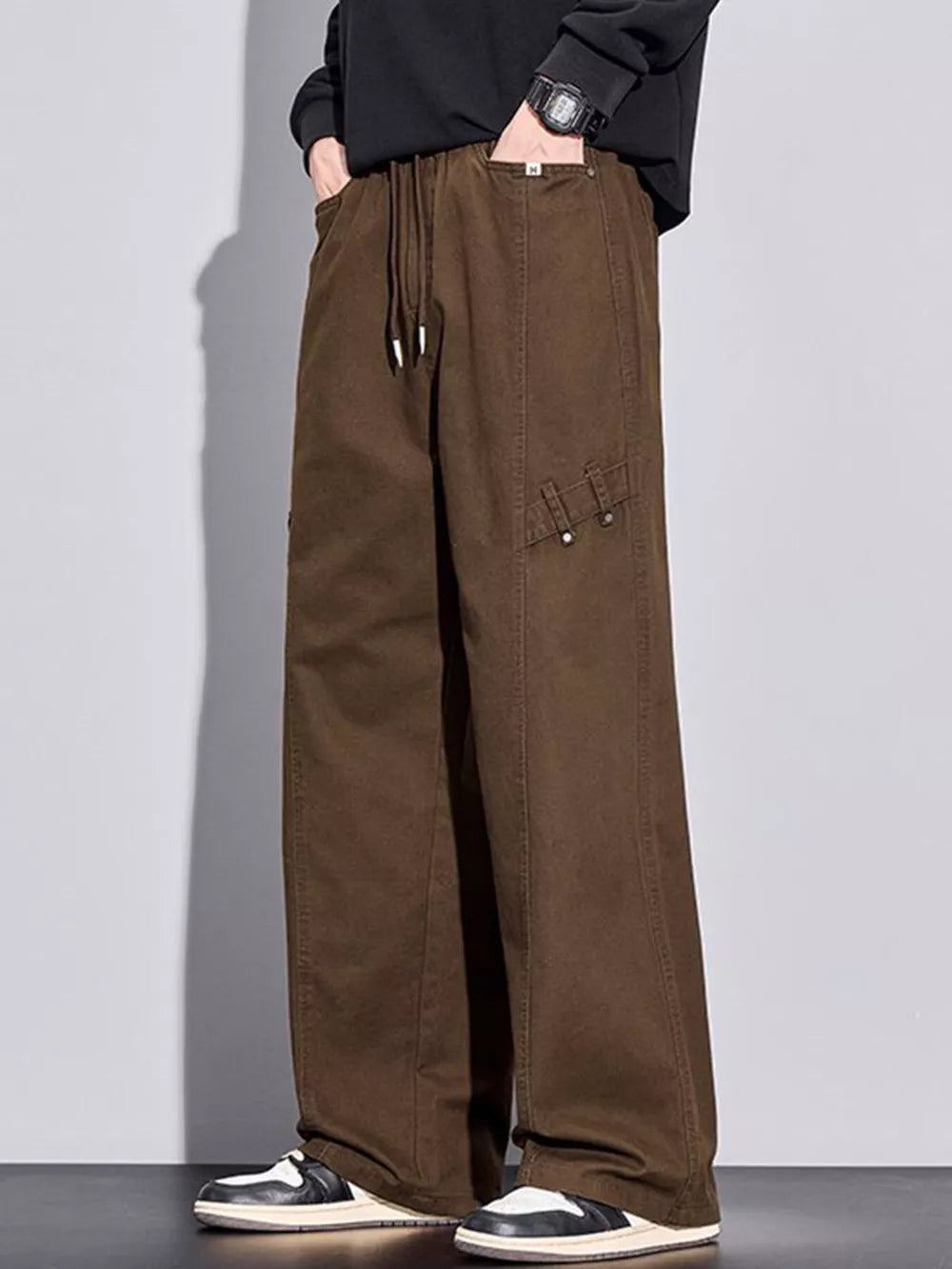 Brown loose-fit men's sweatpants with drawstring and pockets.