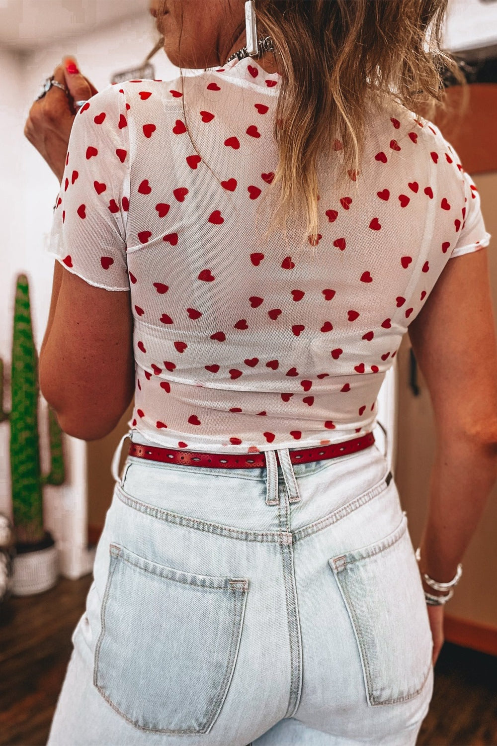 White sheer t-shirt with red hearts, short sleeves, and a cropped fit.