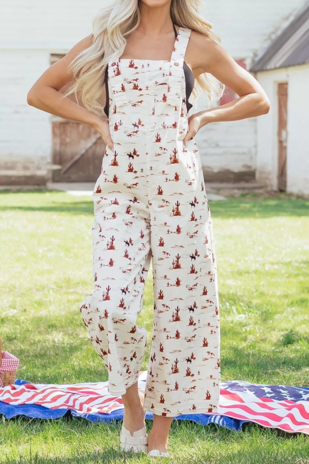 Desert motif adjustable jumpsuit in beige cotton with cropped wide legs and a desert landscape pattern.