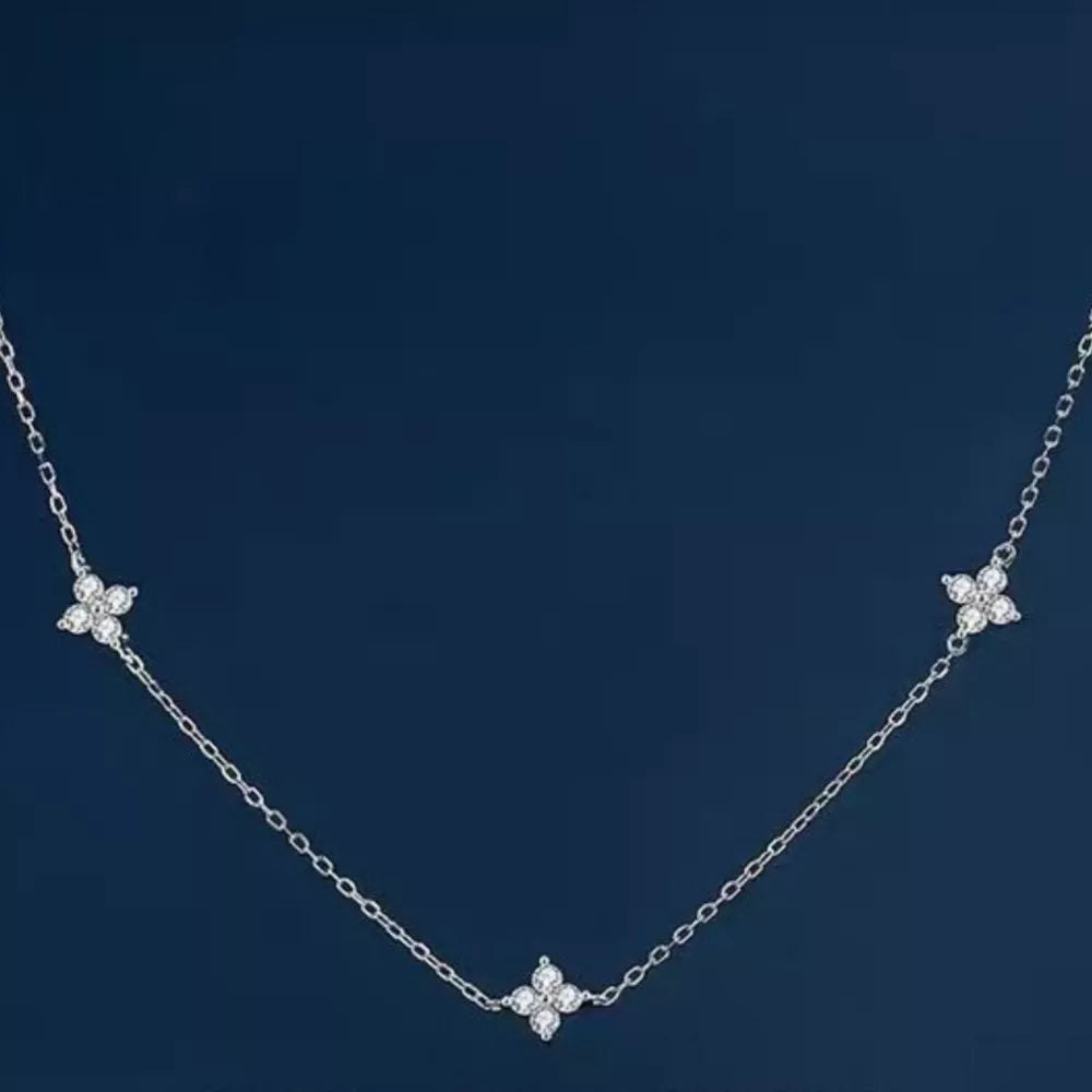 Sterling silver necklace with three delicate clover charms, each with sparkling stones.
