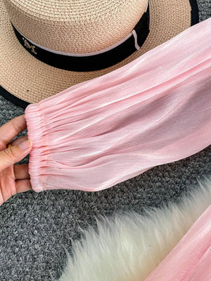 Pink sheer blouse with ruched cuffs and subtle shimmer detail.