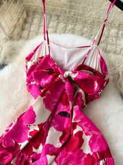 Vibrant floral cami dress with a large back bow detail and spaghetti straps.