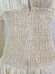White cotton mini dress with corset waist and ruffled details.