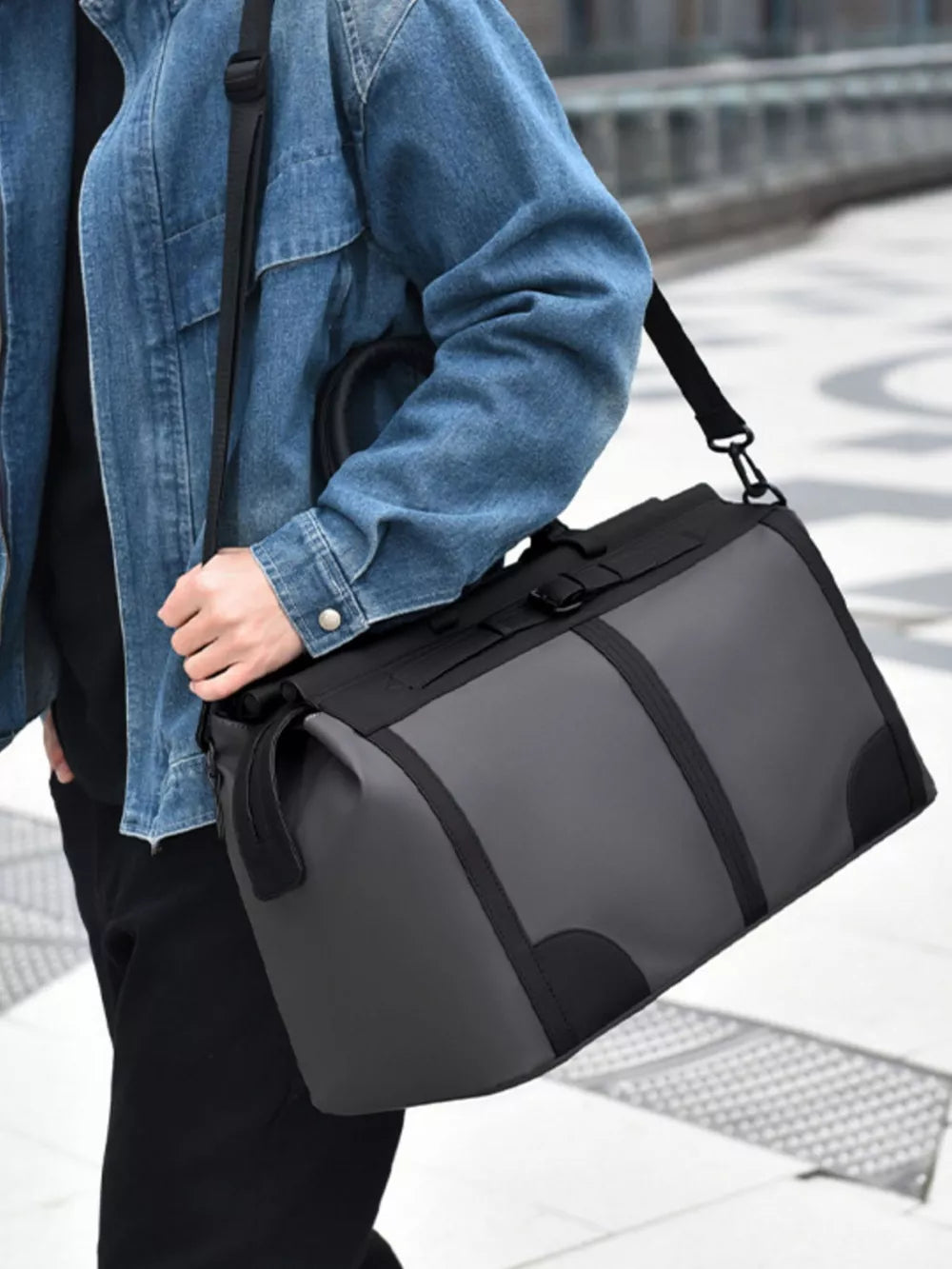 Gray Oxford cloth travel duffel bag with black accents and adjustable strap.