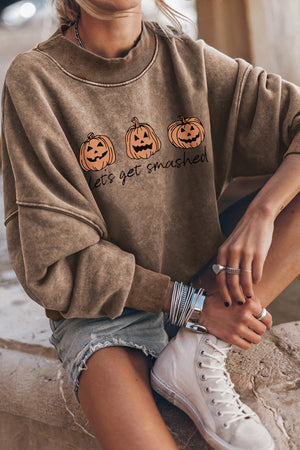 Acid wash camel crewneck sweatshirt with pumpkin print and text graphic.