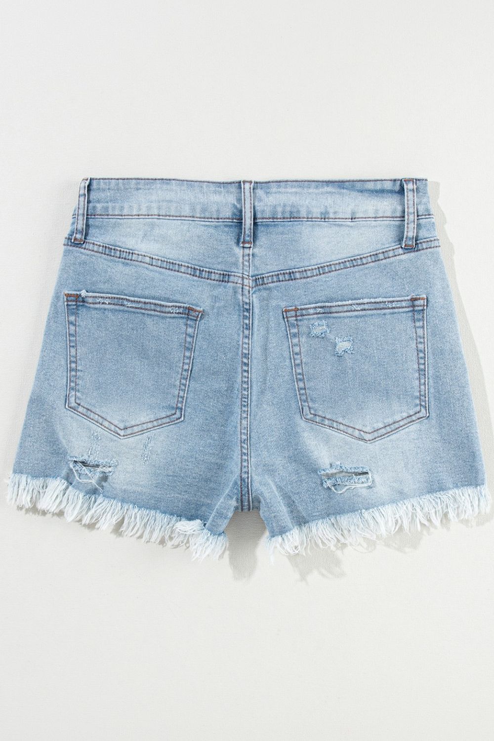 Light blue distressed denim cutoff shorts with frayed hem and ripped details.