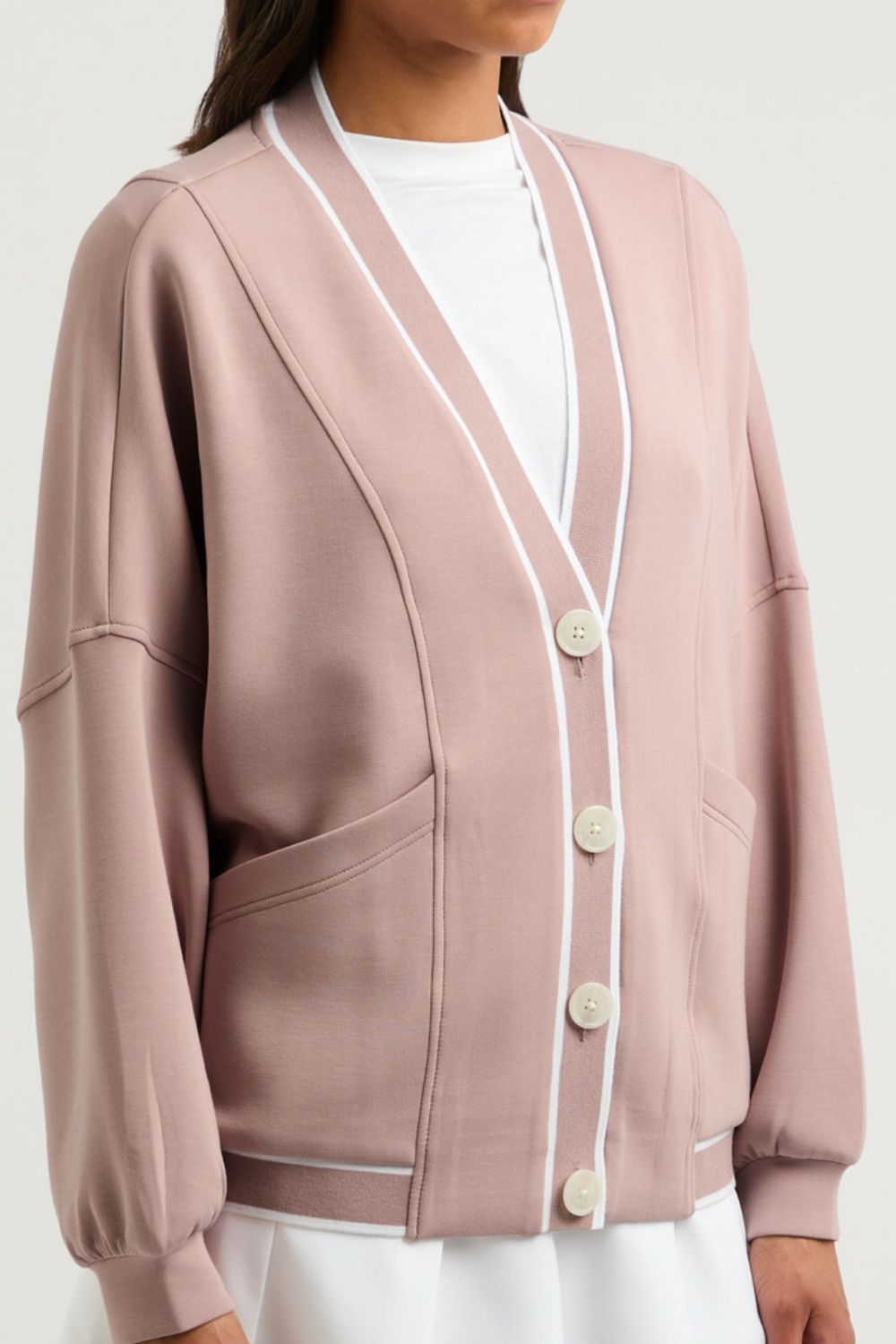 Dusty pink cardigan with white varsity trim, button front, and pockets.