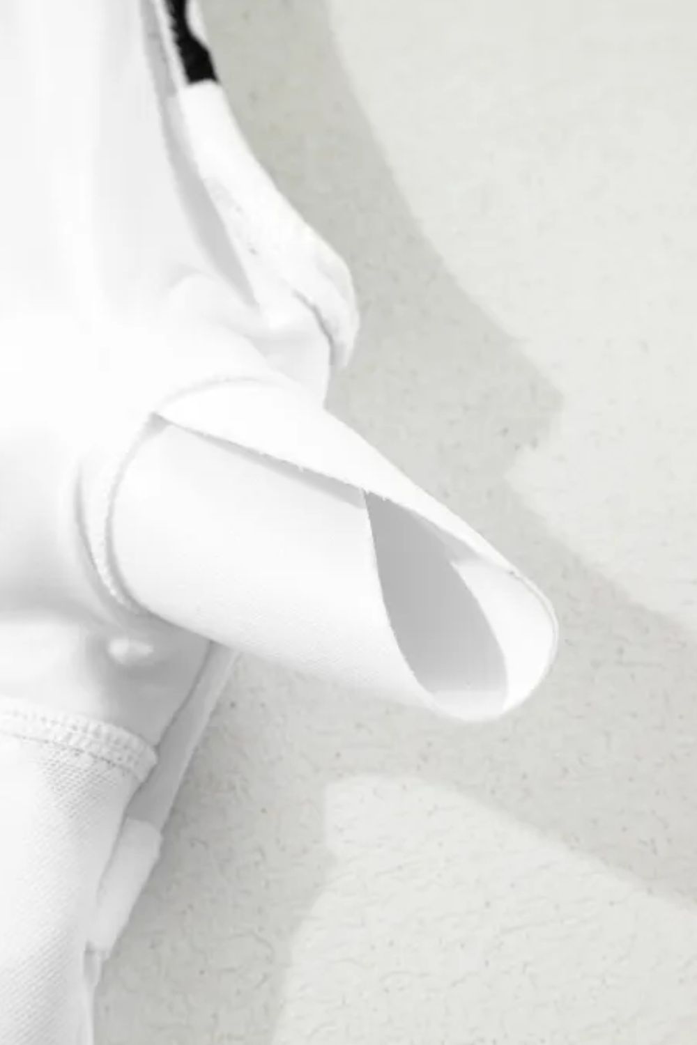 White one-piece swimsuit with a bow-front detail and wave print.