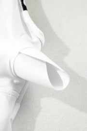 White one-piece swimsuit with a bow-front detail and wave print.