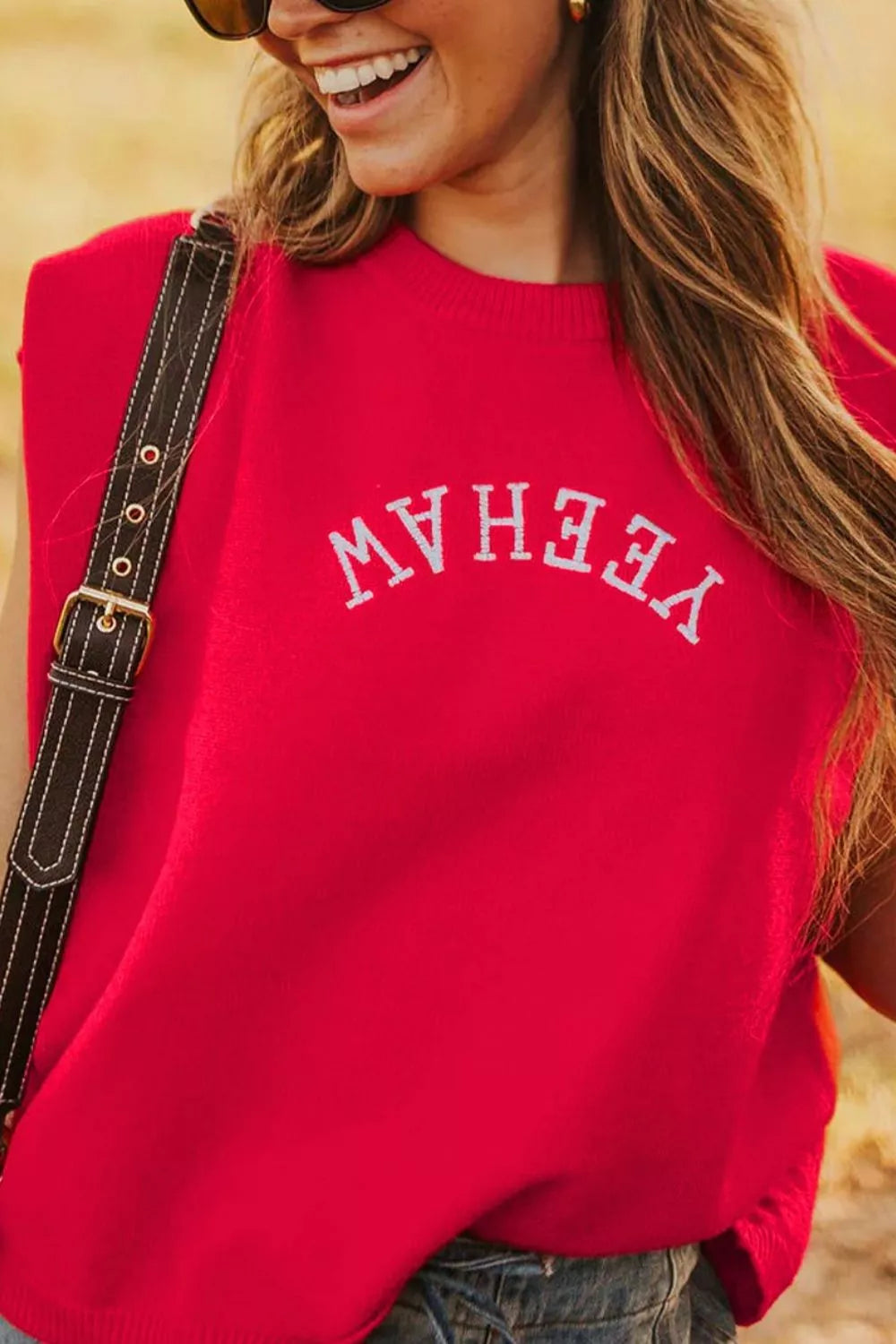 Red crew neck sweater vest with embroidered "Yeehaw" text detail