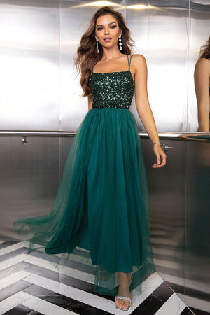 Green sequin bodice tulle maxi dress with spaghetti straps and a flowing skirt.