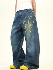 Oversized blue denim jeans with wide legs, yellow heart graphic and paint splatters.