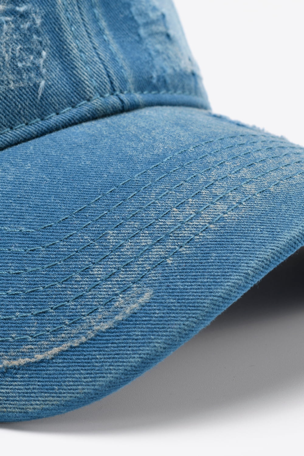 Distressed denim baseball cap with visible stitching details.