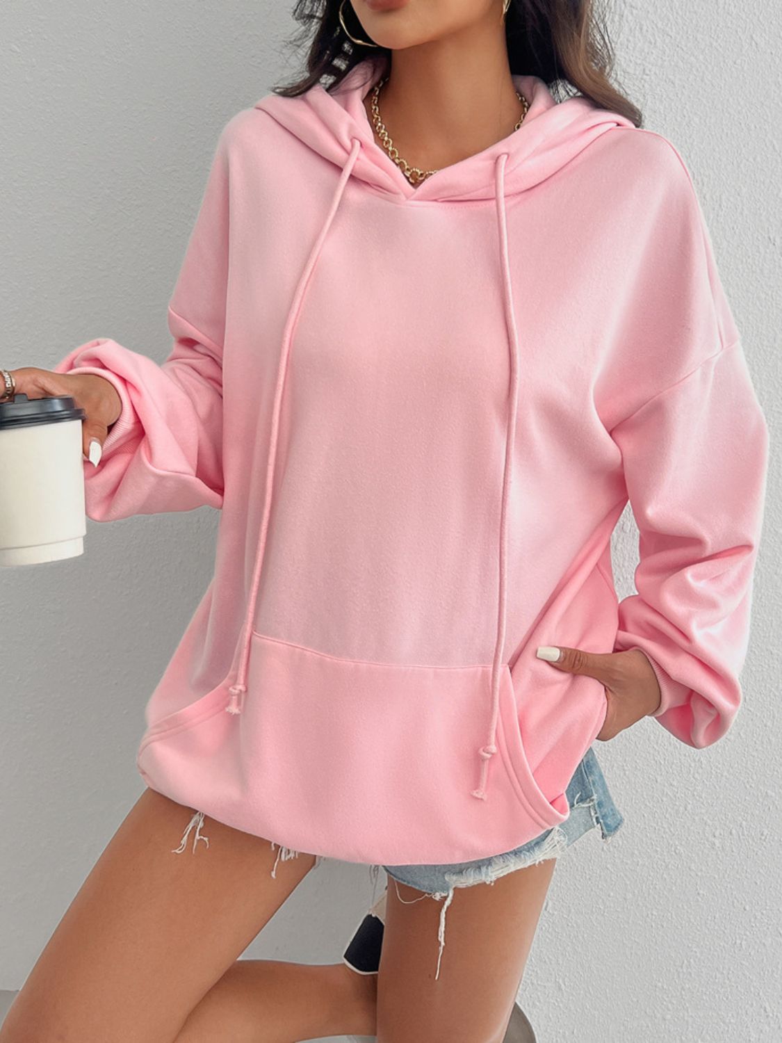 Oversized blush pink hoodie with drawstring detail and front pocket.