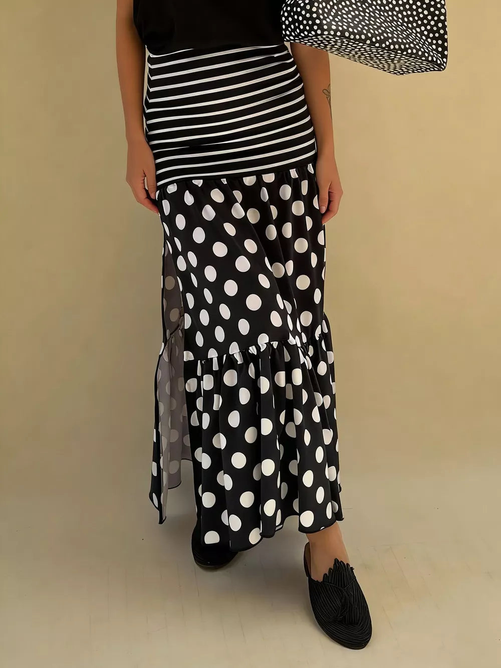 Black polka dot maxi skirt with high slit and tiered ruffle hem.