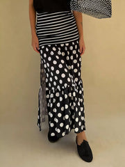 Black polka dot maxi skirt with high slit and tiered ruffle hem.