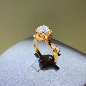 Gold floral halo moissanite statement ring with pear-shaped accent stones.