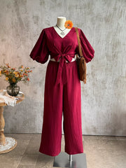 Deep red textured tie-front crop top with balloon sleeves and wide-leg pants set.