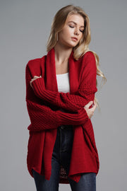 Red knit batwing cardigan with drape front and textured sleeves.