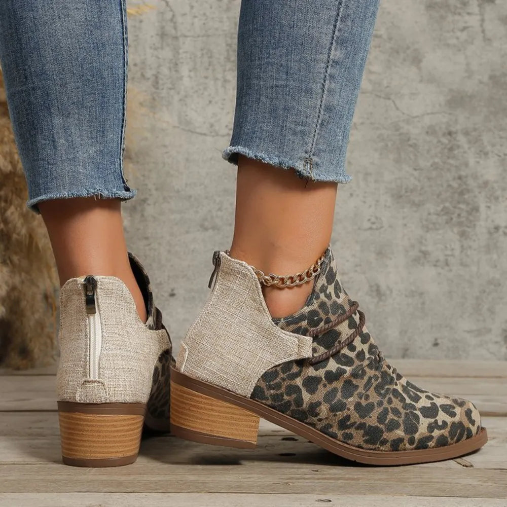 Leopard print ankle boots with cutout sides, chain detail, and back zipper.
