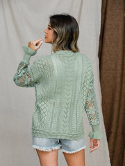 Light green openwork sleeve knit sweater with ruffled cuffs and intricate stitch patterns.