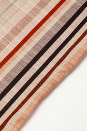 Striped square neck wide-leg romper in tan with rust, brown, and grey stripes.