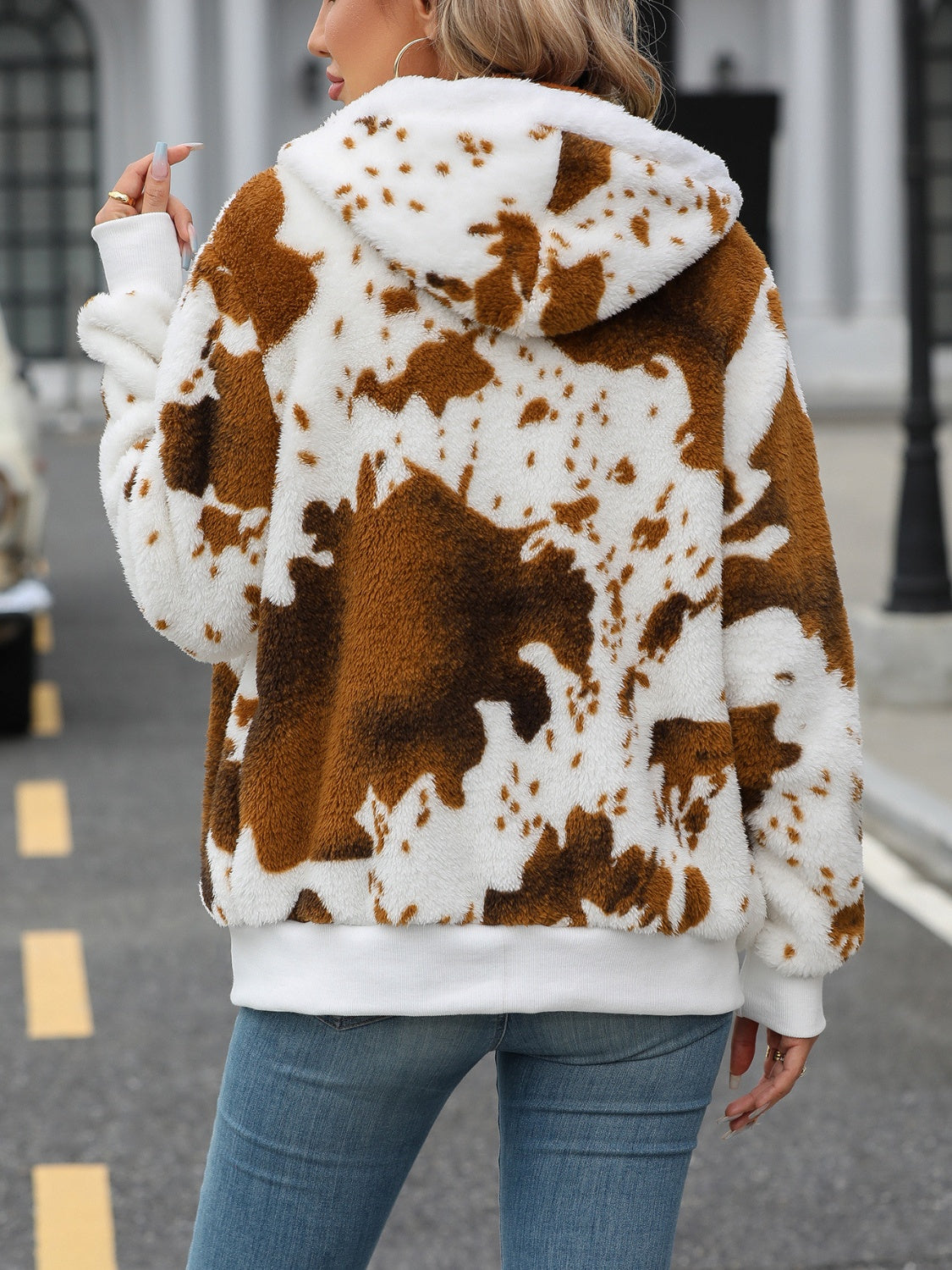 Brown cowhide print sherpa zip-up hoodie with white trim and hood.