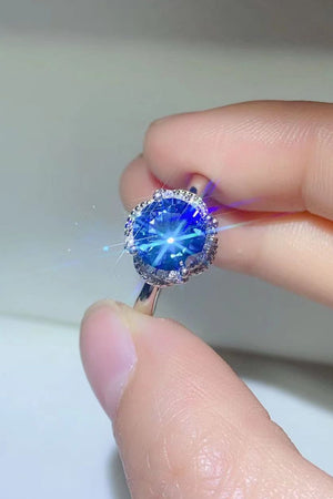 Blue moissanite cocktail ring with a diamond halo setting.