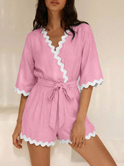 Pink maternity wrap romper with white scalloped trim and 3/4 sleeves.