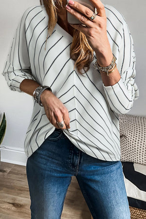 Chevron stripe v-neck blouse in white with black pinstripes, relaxed fit, long sleeves.