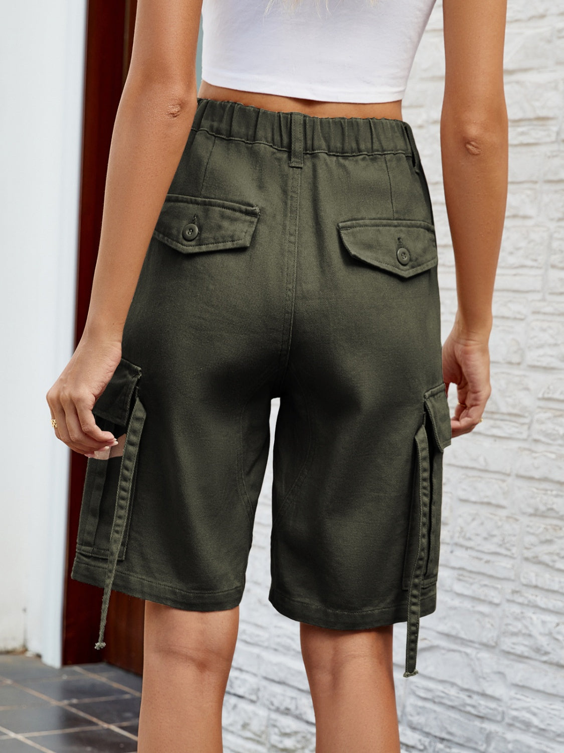 Army green denim bermuda shorts with cargo pockets and buttoned flaps.