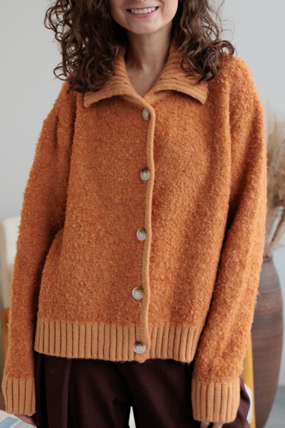 Textured bouclé collar cardigan in tangerine with button front and ribbed cuffs and hem.