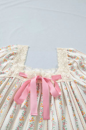 Floral mini dress with lace trim, square neck, pink bow detail, and puff sleeves.
