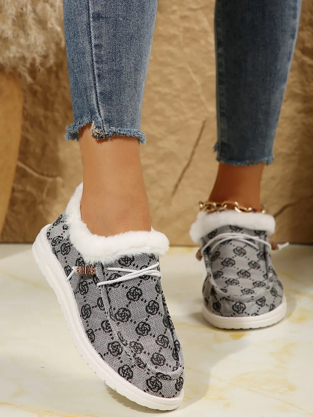 Gray Southwestern print faux fur lined loafers with white laces and wooden button detail.