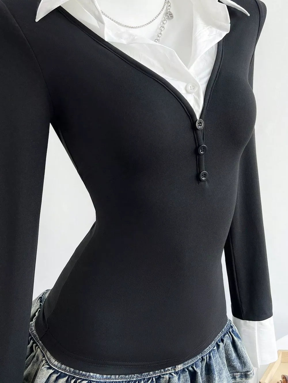 Black polo collar slim fit t-shirt with button detail and white collar peeking out.