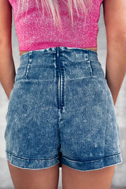 Denim skort in medium wash with a back zipper and buckle detail.
